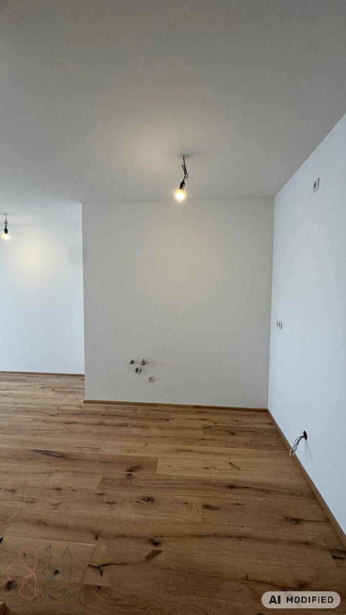 Heller, leerer Raum mit Holzboden und weißen Wänden, bereit für die weitere Gestaltung.