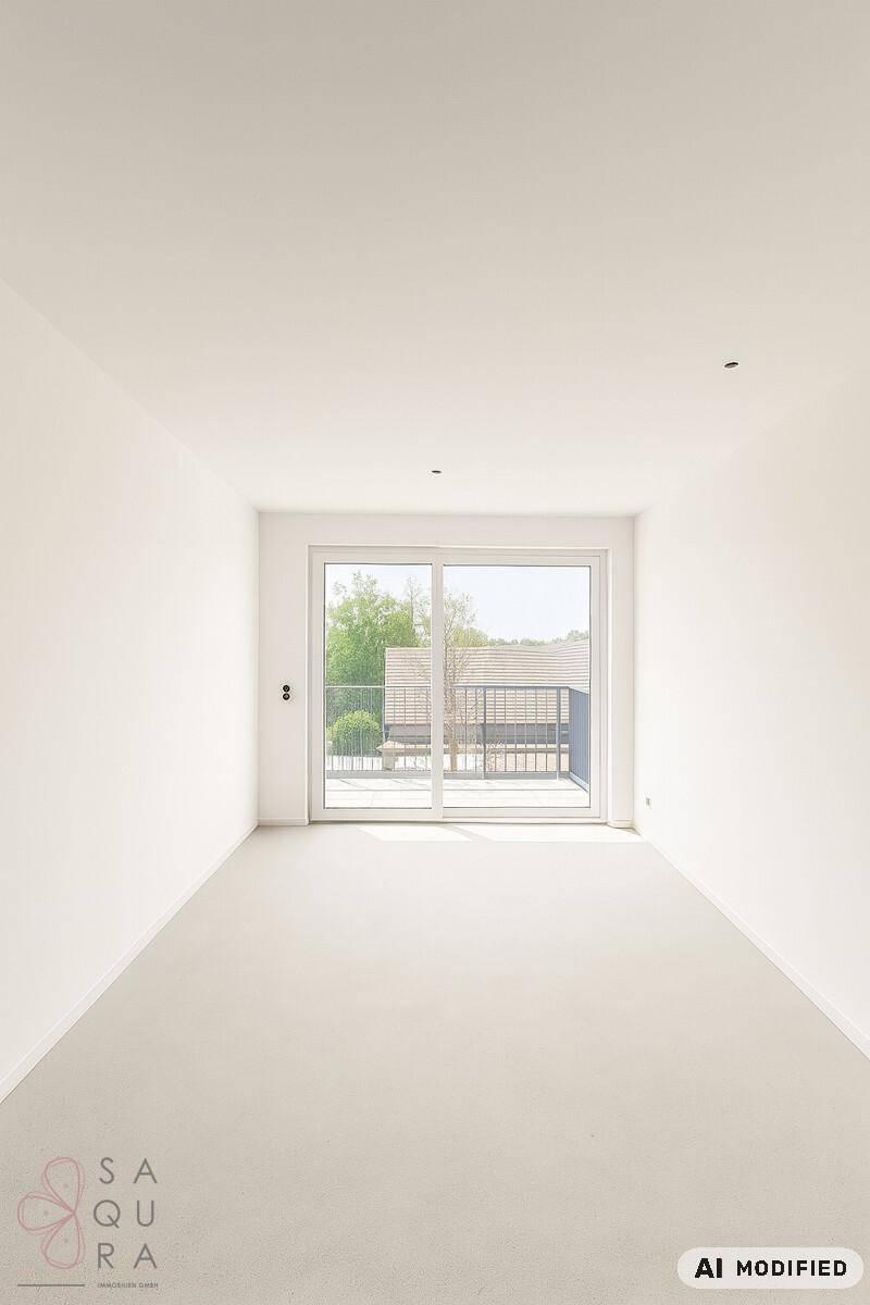 Heller, leerer Raum mit Teppichboden und großen Fenstern, die Zugang zu einem Balkon bieten.