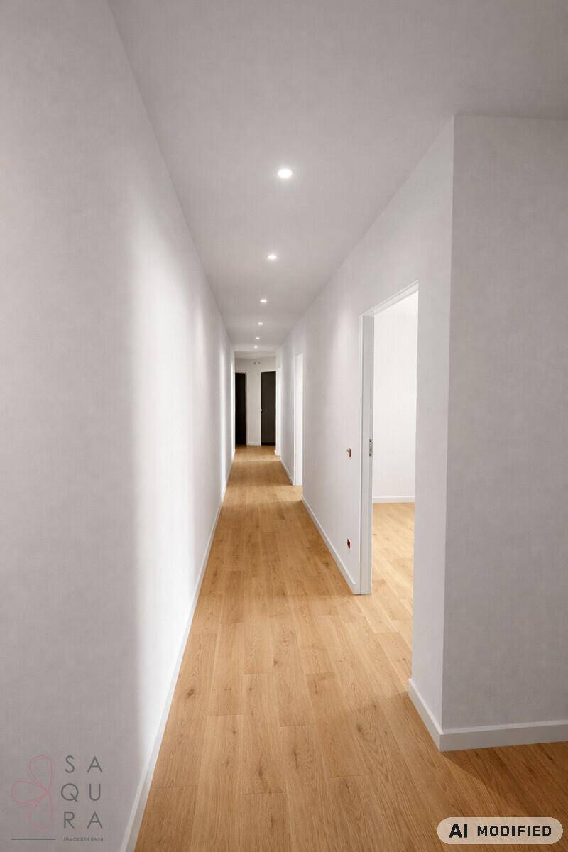 Langer, heller Flur mit Holzboden und integrierter Deckenbeleuchtung, der zu weiteren Räumen führt.