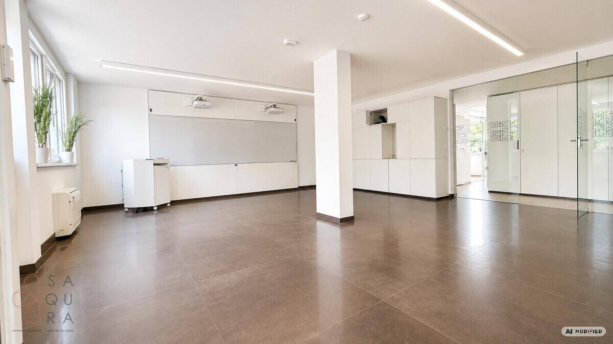 Großer, heller Büroraum mit modernen Fliesen, weißen Wänden und integrierten Schränken.