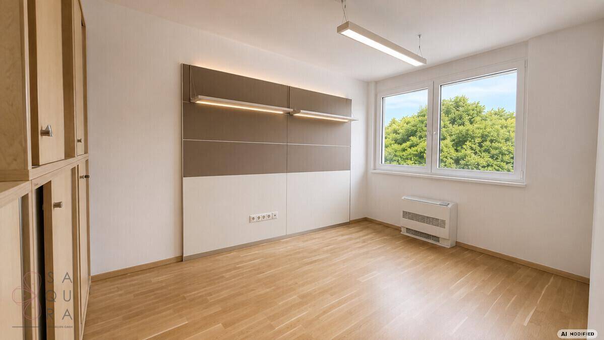 Heller Raum mit Holzboden, großen Fenstern und einer modernen Wandgestaltung.