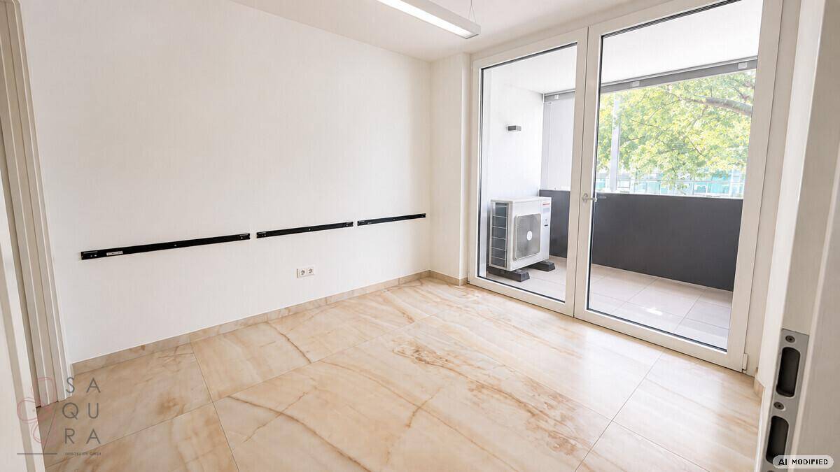 Leerer Raum mit Steinboden und Zugang zu einem Balkon, ideal für verschiedene Nutzungen.