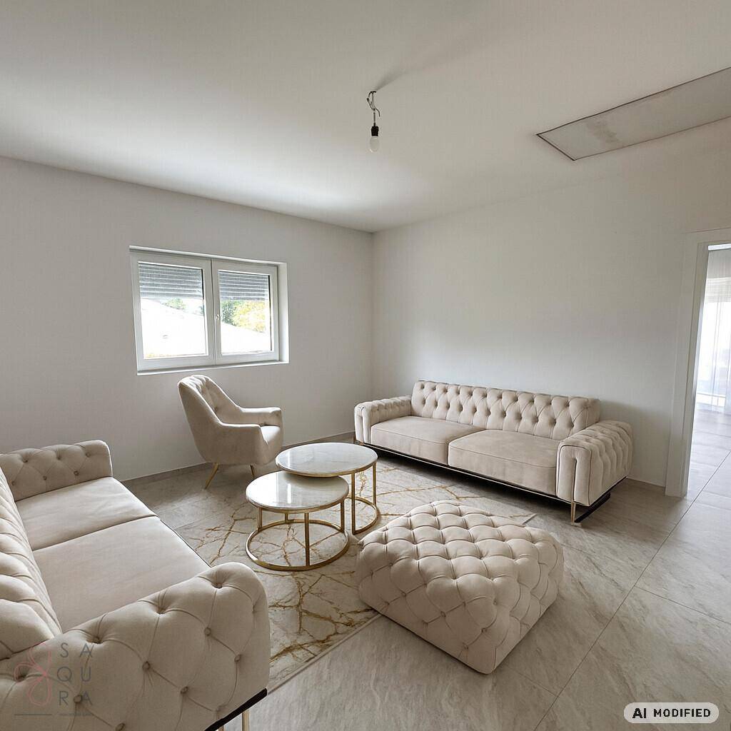 Helles Wohnzimmer mit beigen Sofas, Teppich und großen Fenstern.