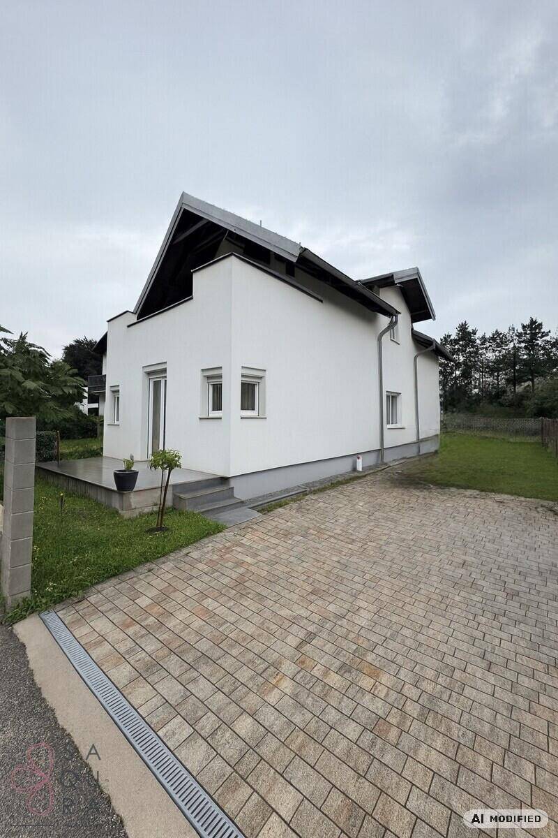 Freistehendes Haus mit gepflasterter Auffahrt und Garten.