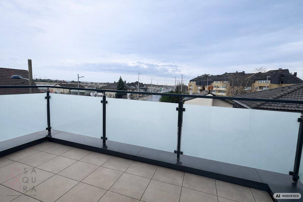 Geräumiger Balkon mit moderner Glasbrüstung und Blick auf die städtische Umgebung.