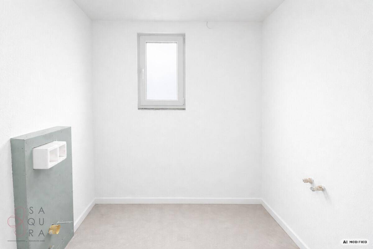 Unmöblierter Raum mit Fenster und vorbereiteten Anschlüssen für Sanitärinstallationen.
