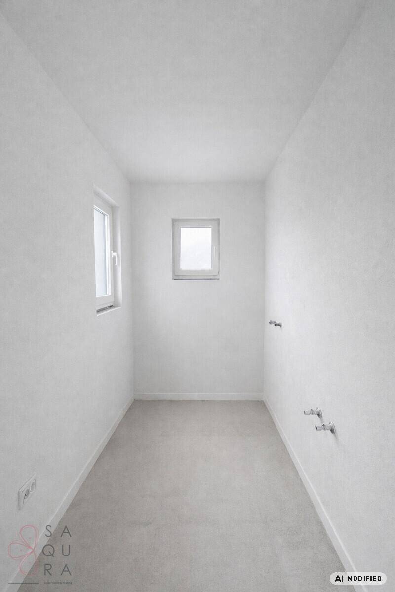 Unmöblierter Raum mit zwei Fenstern und vorbereiteten Anschlüssen für Sanitäranlagen.