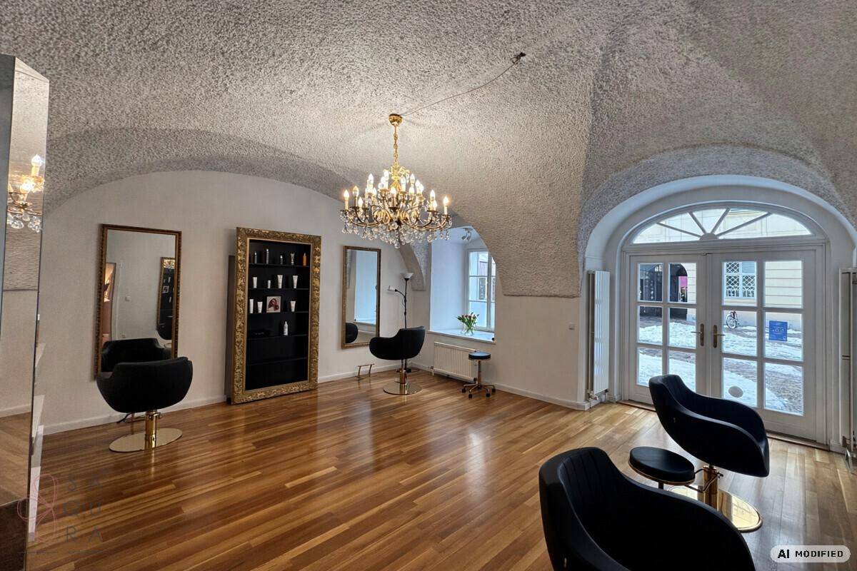 Friseursalon mit schwarzen Stylingstühlen, Spiegeln und einem Kronleuchter unter gewölbter Decke.