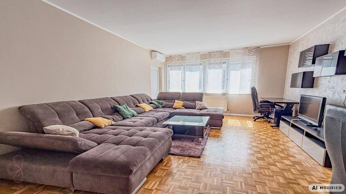 Weitläufiger Wohn- und Essbereich mit bequemer Eckcouch und Parkettboden, gut beleuchtet.