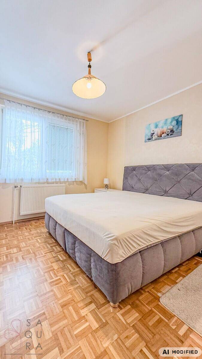 Helles Schlafzimmer mit großem Bett, Parkettboden und Fenster, mit Nachttischen.
