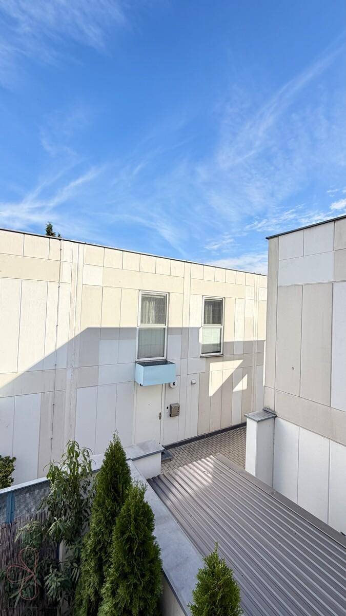 Moderne Gebäudefassaden unter einem klaren blauen Himmel mit einigen Wolken.