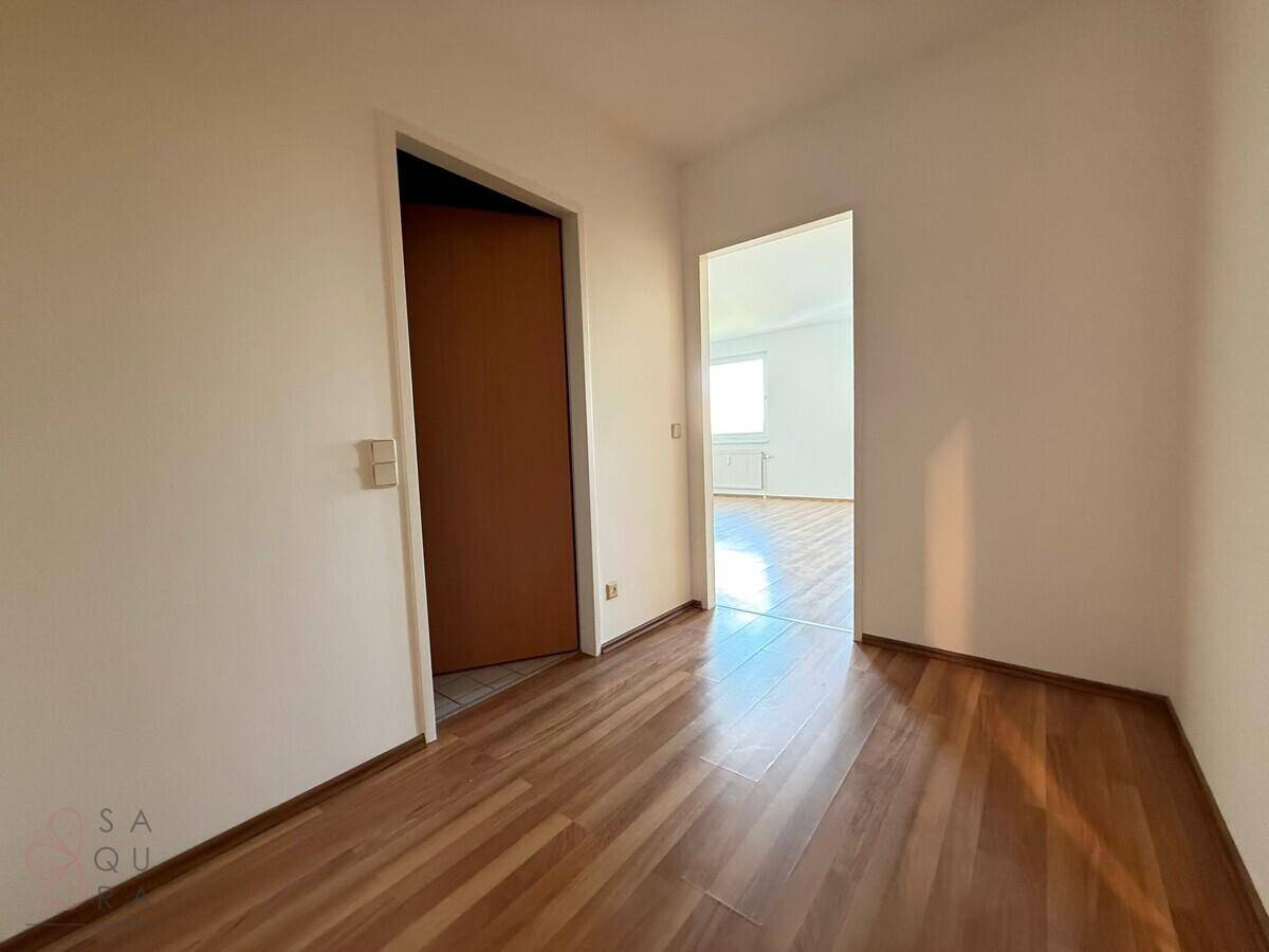 Heller Flur mit Laminatboden, der zu verschiedenen Räumen der Wohnung führt.