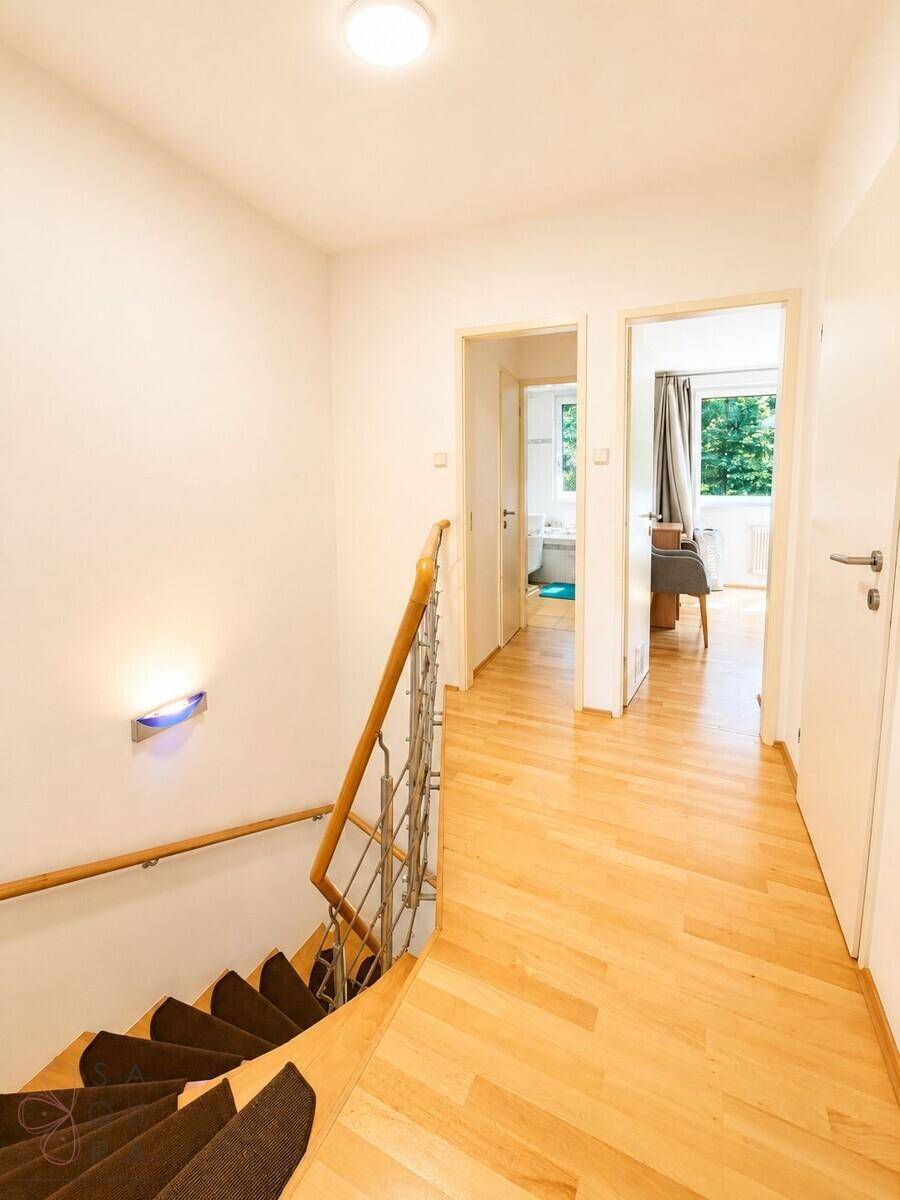 Heller Flur im Obergeschoss mit Holzfußboden und Zugang zu weiteren Zimmern.