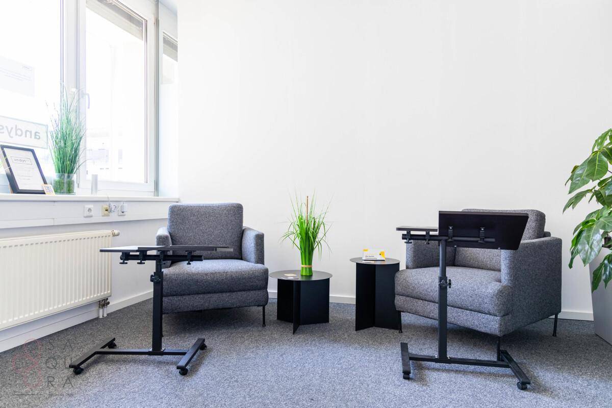 Ruhiger Loungebereich im Büro mit bequemen Sesseln und mobilen Beistelltischen für flexible Nutzung.