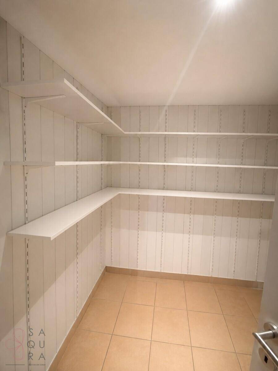 Praktischer Abstellraum mit vielen weißen Regalen für zusätzlichen Stauraum.