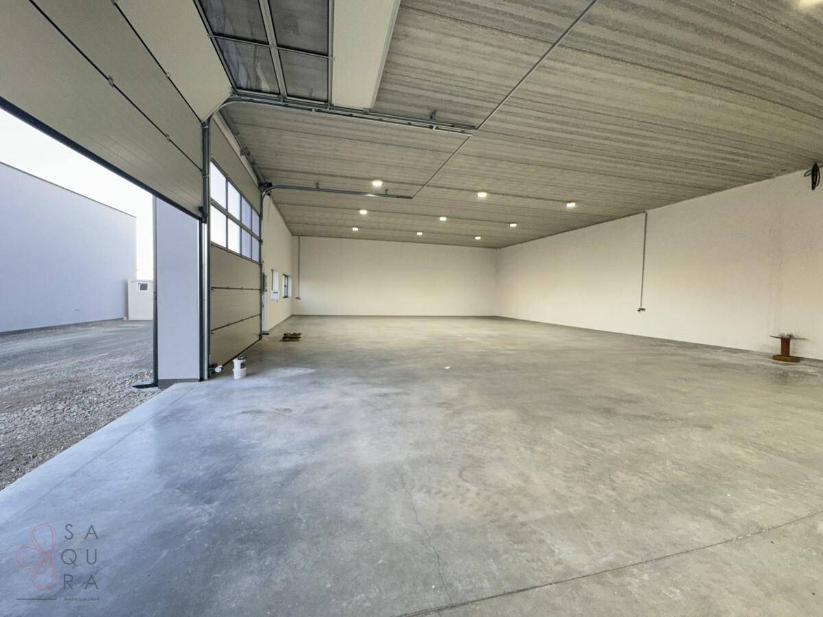 Heller und weitläufiger Lagerraum mit glattem Betonboden und modernen Deckenleuchten.