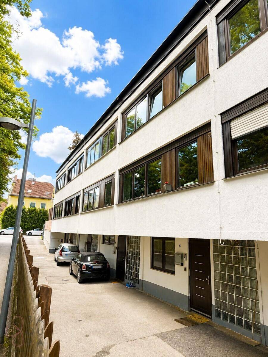 Fassade des modernen Gebäudes mit mehreren Eingängen und großen Fenstern.