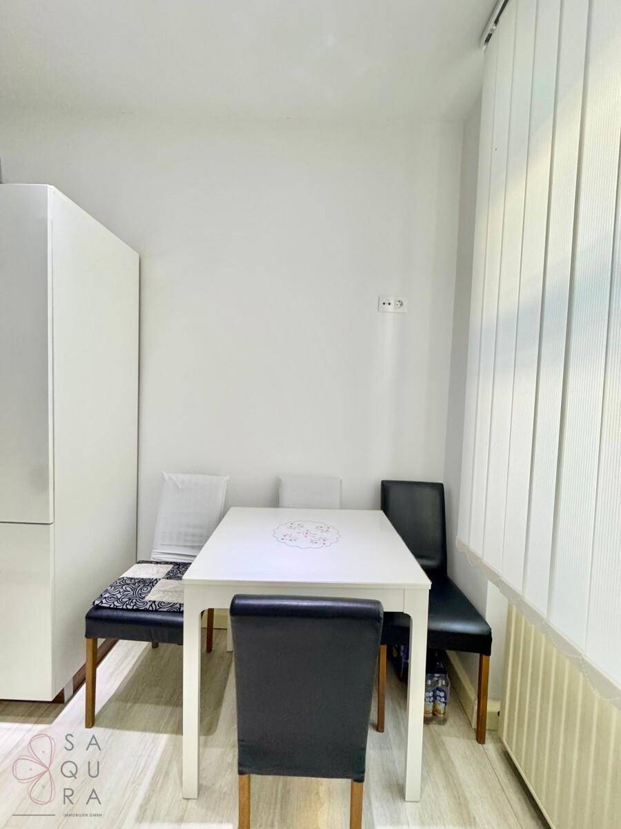 Kleiner Essbereich mit weißem Tisch und Sitzbank, ideal für Frühstück oder schnelle Mahlzeiten.