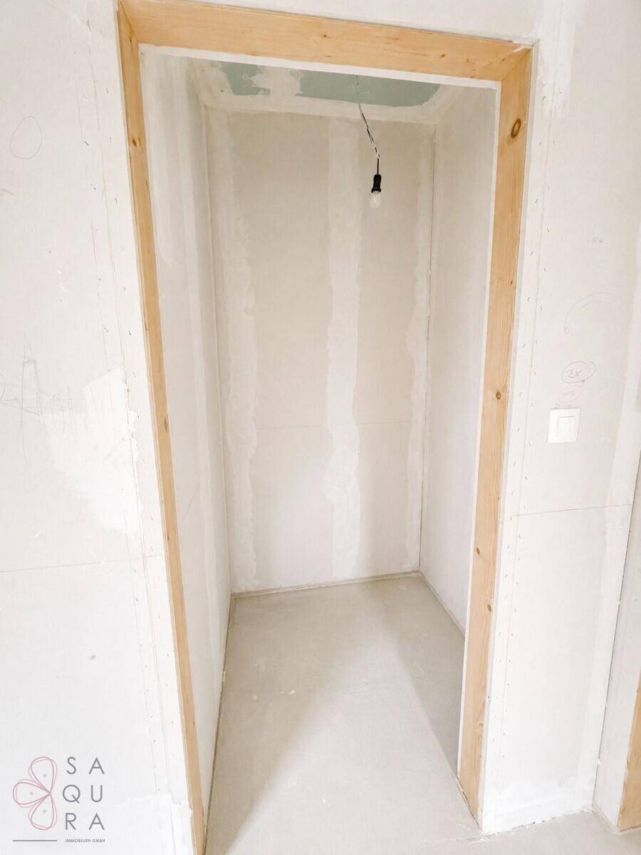 Unfertiger Raum für einen begehbaren Kleiderschrank im Rohbauzustand.