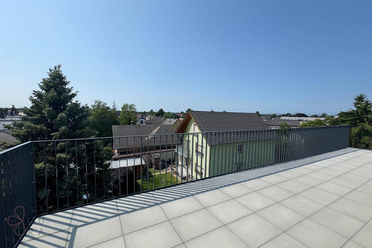 Geräumige Dachterrasse mit Fliesenboden und weitem Blick über die Nachbarschaft und Bäume.