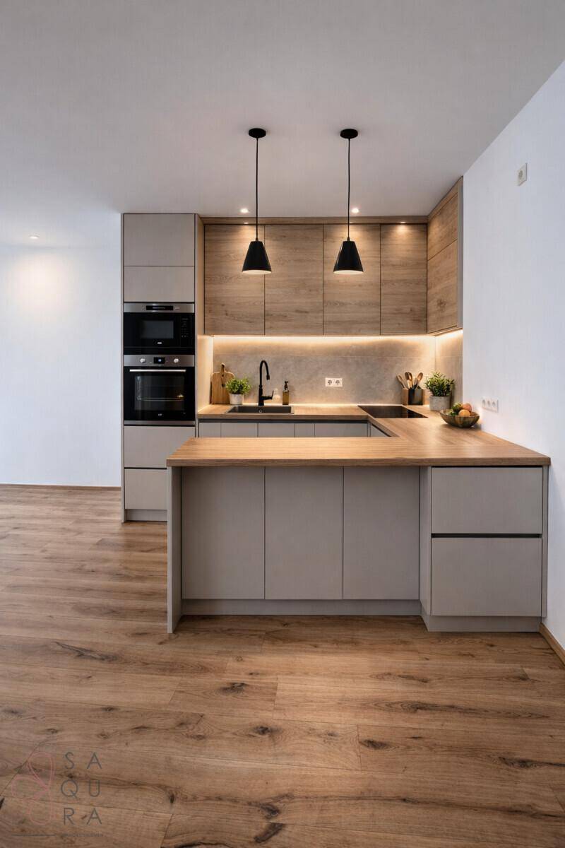 Moderne Einbauküche mit Holz- und Grautönen, integrierten Geräten und indirekter Beleuchtung.