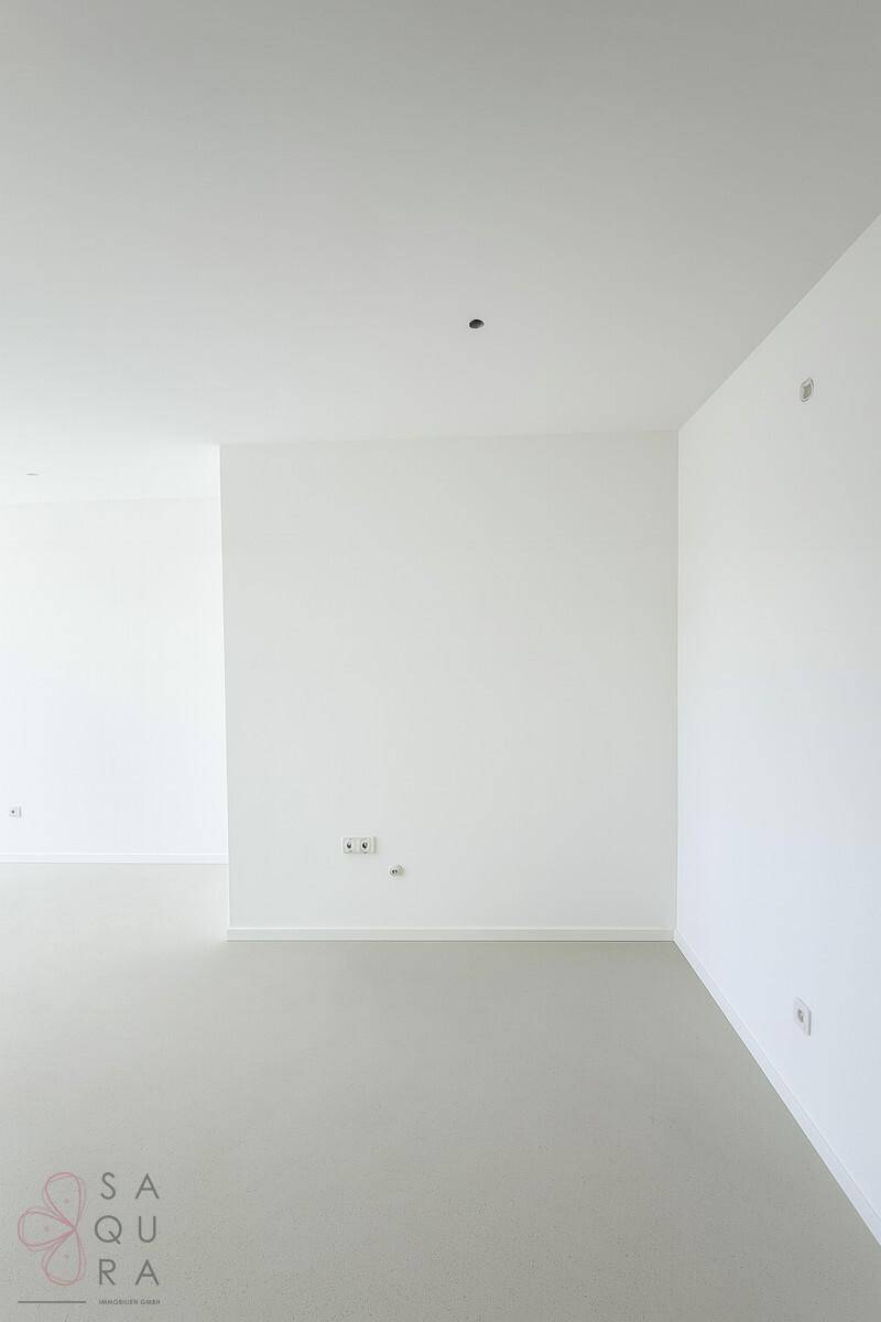 Leerer Raum mit hellem Boden und weißen Wänden, ideal für individuelle Gestaltung.