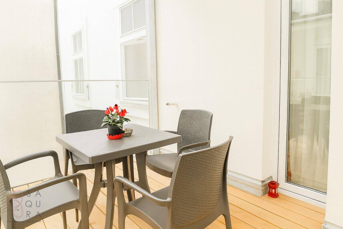 Kleiner Balkon mit Tisch und Stühlen, ideal für entspannte Stunden im Freien.