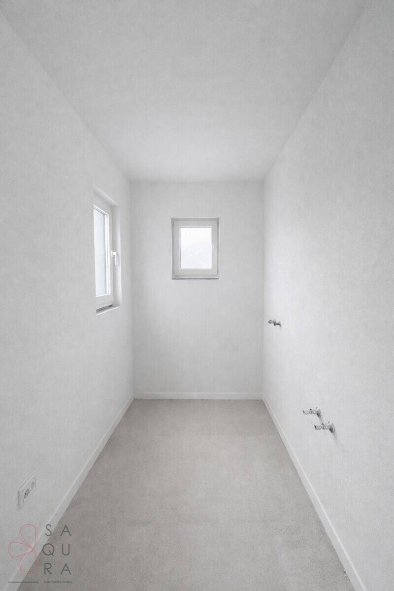 Helles Badezimmer mit Fenster und Estrichboden, bereit für die Installation der Einrichtung.