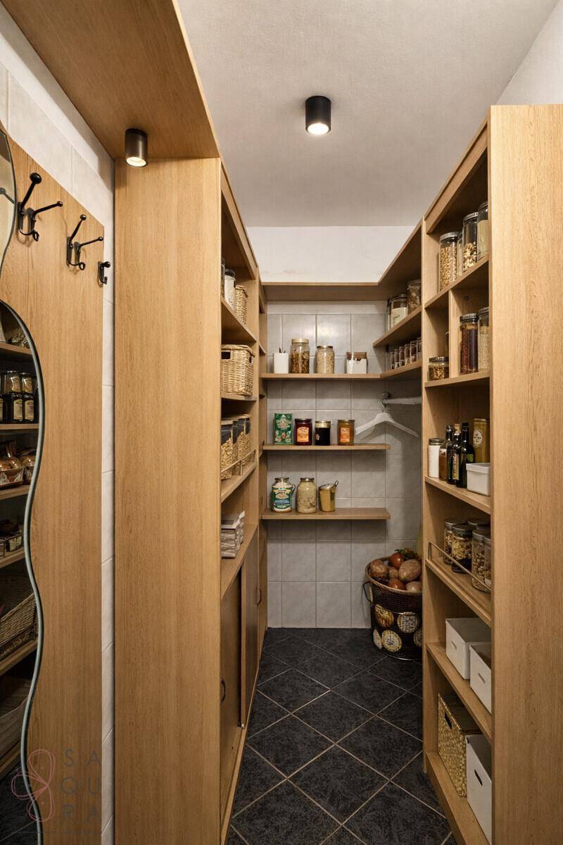 Gut organisierte Speisekammer mit vielen Holzregalen und Vorräten, ideal für die Lagerung.