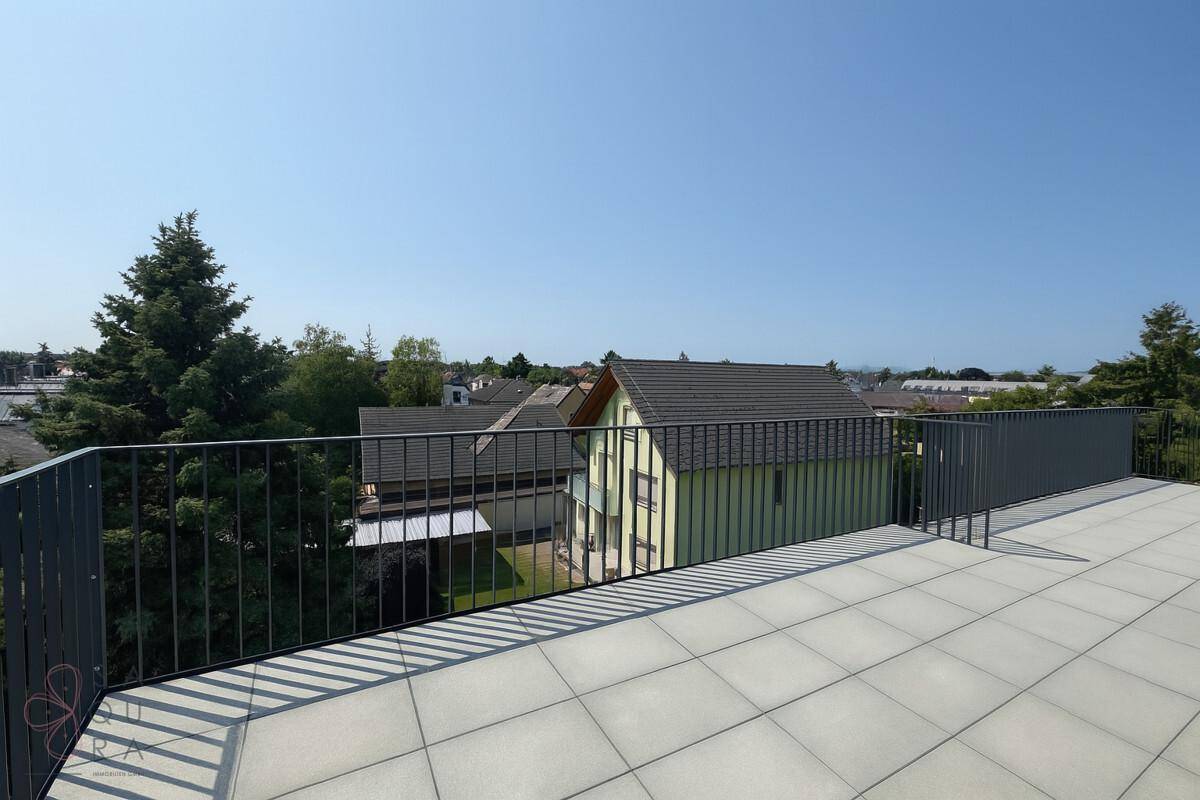 Weitläufige Dachterrasse mit Fliesenboden und Panoramablick auf die umliegende Landschaft.