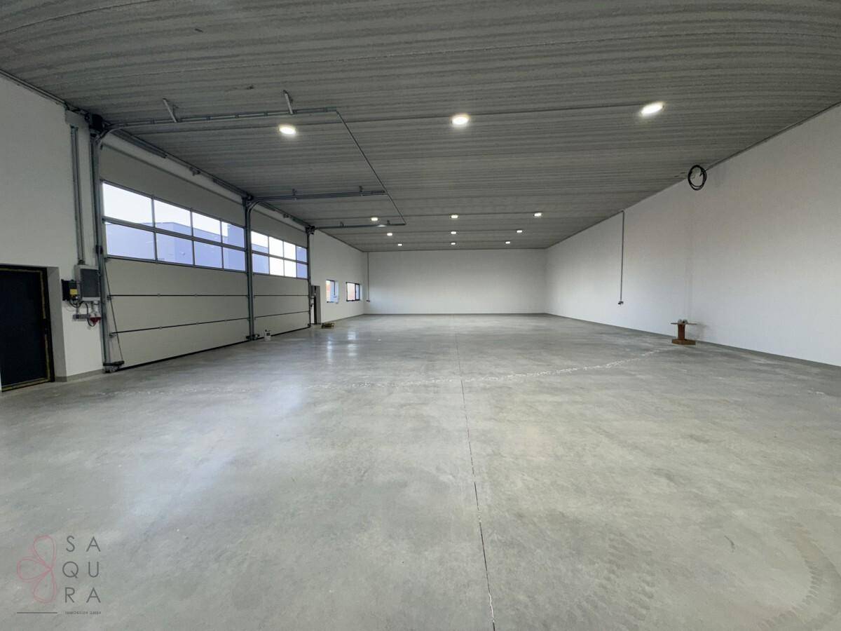Heller und weitläufiger Lagerraum mit glattem Betonboden und modernen Deckenleuchten.