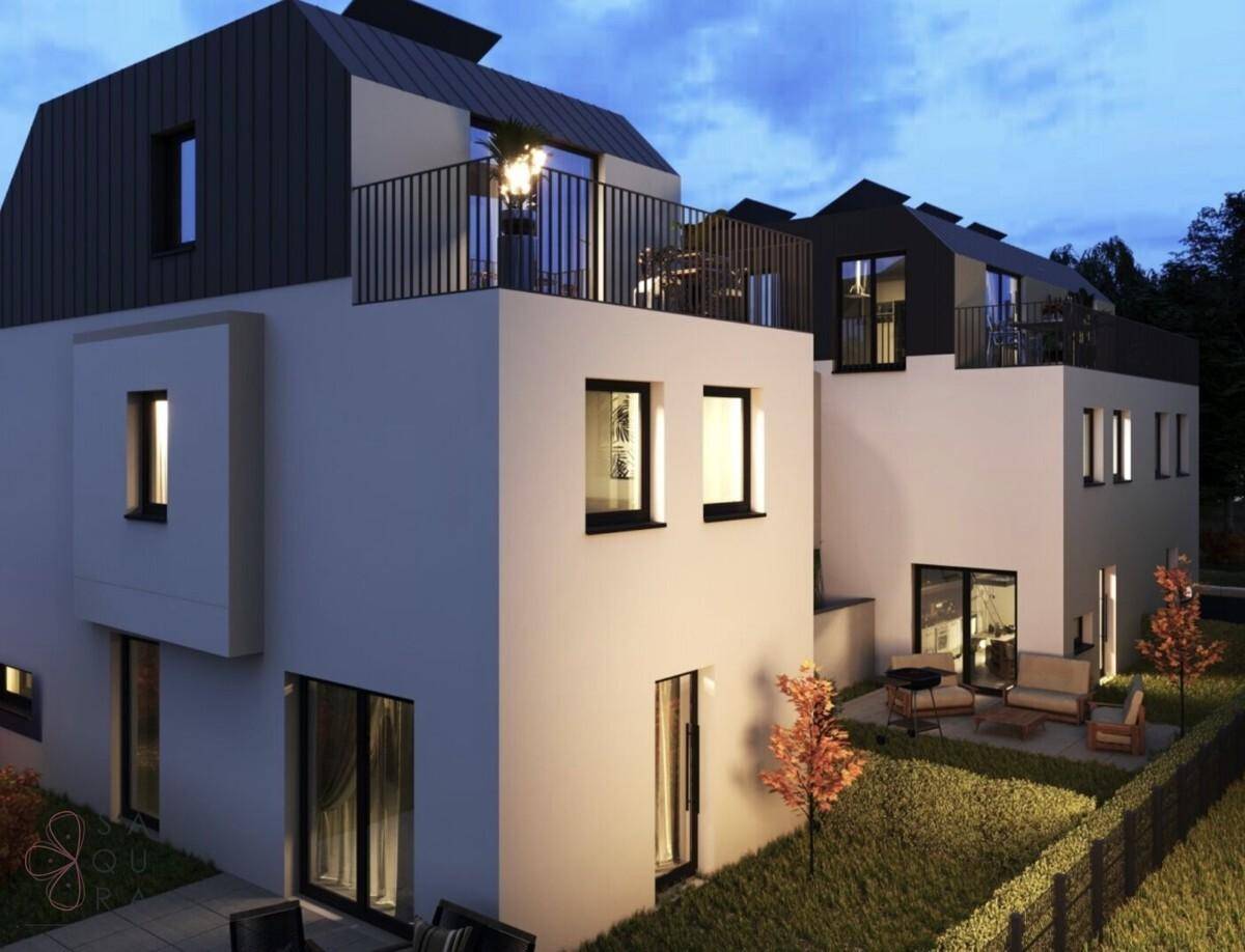 Moderne Reihenhäuser mit Terrassen und Gärten in der Abenddämmerung, beleuchtet.