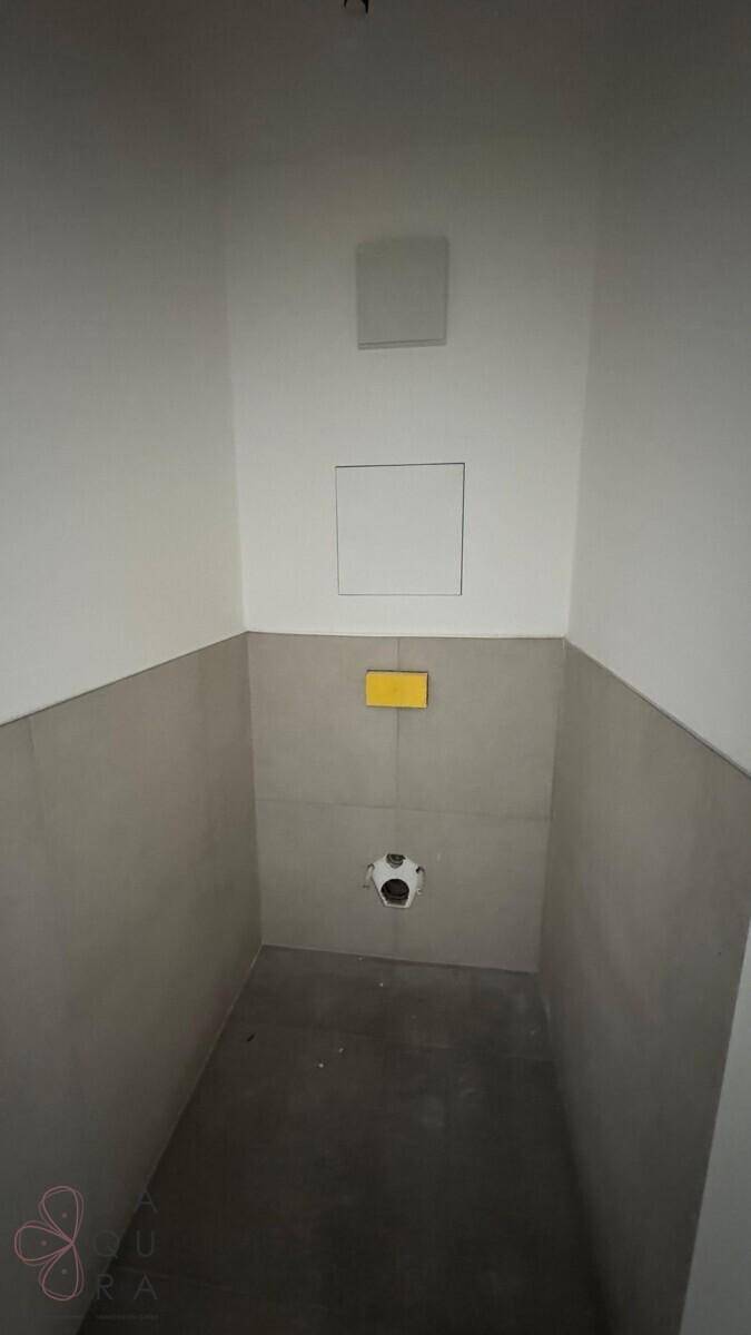 Kleines, gefliestes WC im Bau mit Vorbereitung für eine wandhängende Toilette und gelber Spülplatte.