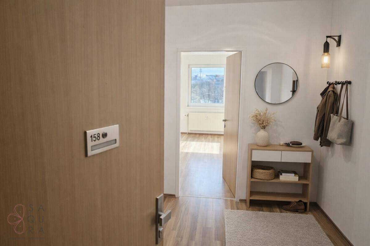 Einladender Eingangsbereich mit Holztür, Spiegel und kleiner Ablagefläche.