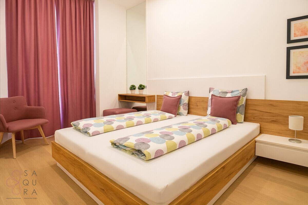 Modernes Schlafzimmer mit großem Bett, Holzkopfteil und Nachttischen, farbenfrohe Bettwäsche.