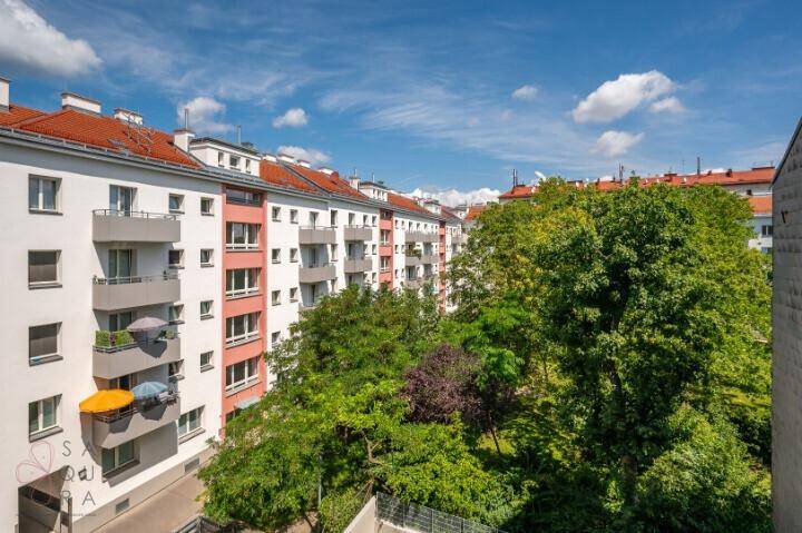Blick auf eine Reihe von Wohngebäuden mit Balkonen und üppigem Grün.