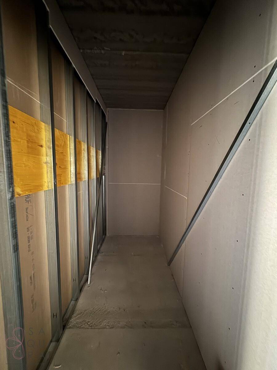 Schmaler Flur im Bau mit Trockenbauwänden und Metallständern, der auf den weiteren Ausbau wartet.