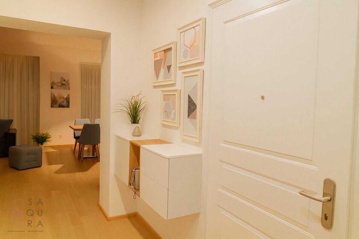 Eingangsbereich mit moderner Wanddekoration und Garderobe, hell und einladend gestaltet.