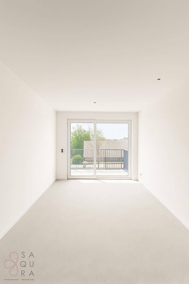 Heller, leerer Raum mit hellem Boden und Schiebetür zum Balkon, vielseitig nutzbar.
