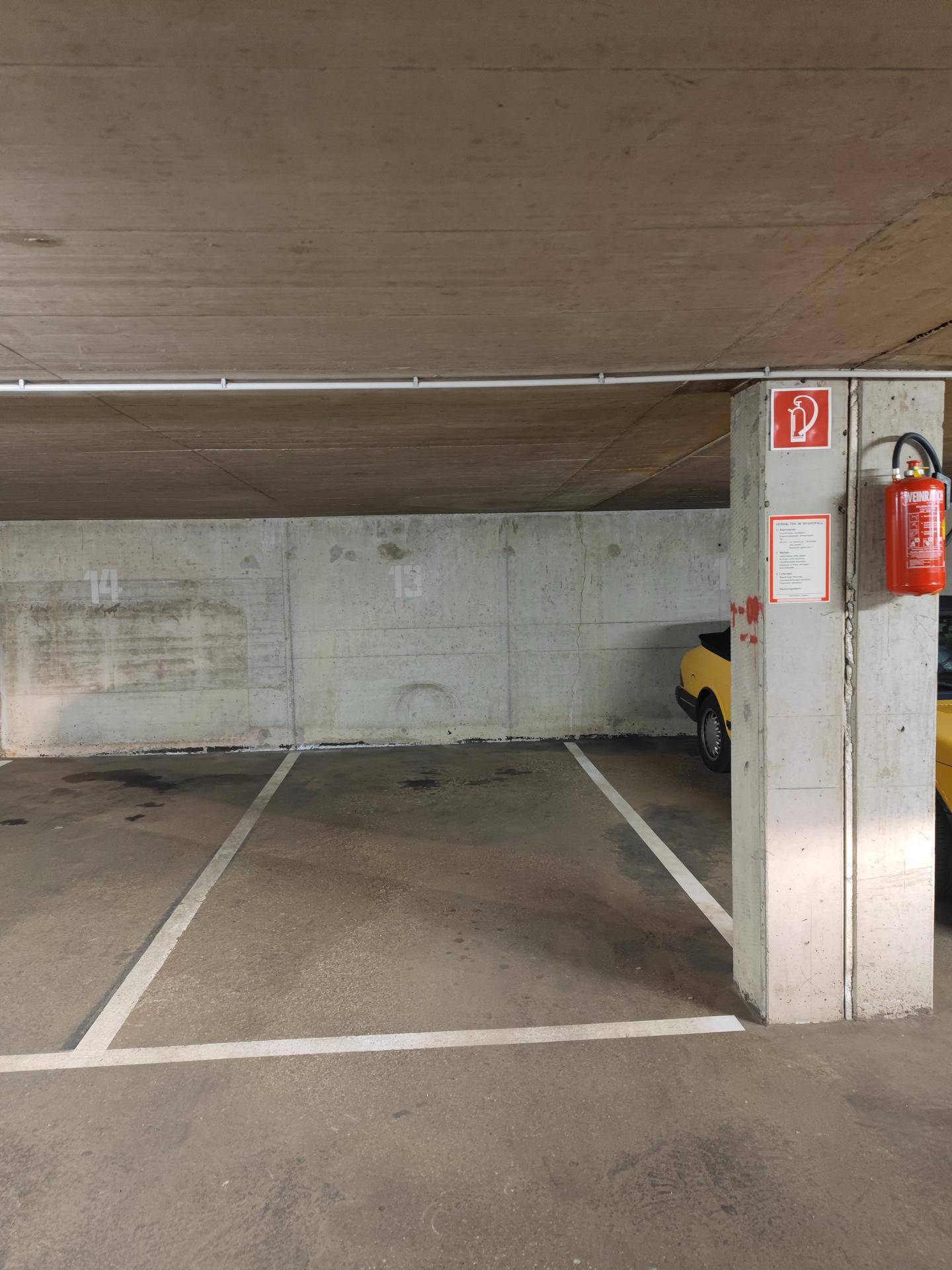 Tiefgaragenstellplatz mit Betonwänden und Markierungen, bietet sicheren Parkraum.