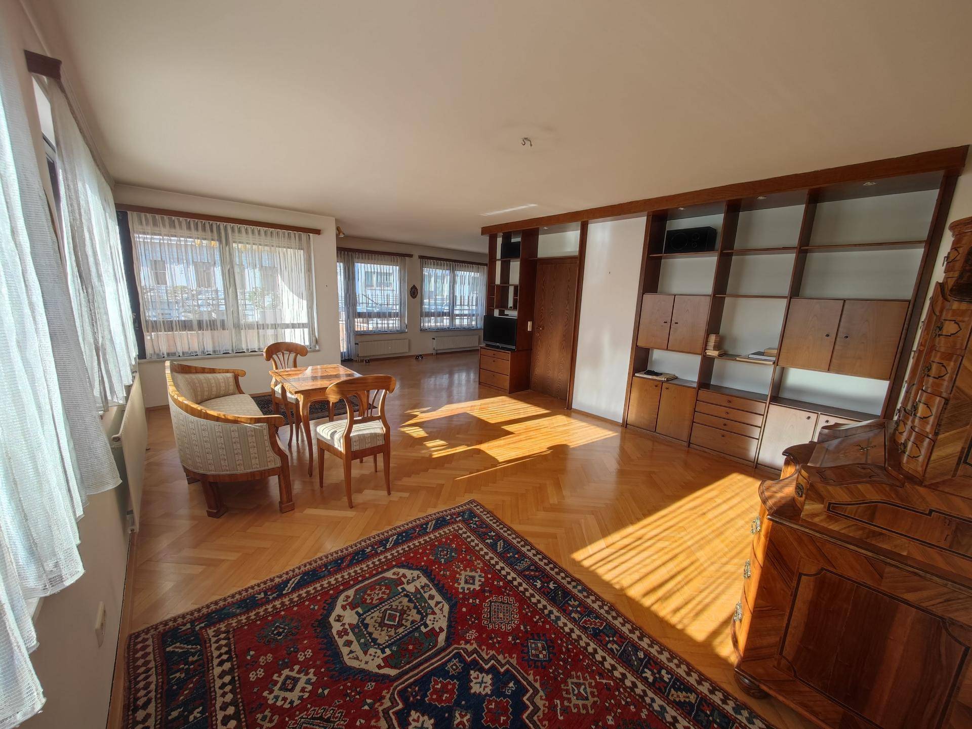 Heller Wohn-Essbereich mit Holzparkett und integrierten Regalen, bietet viel Platz und Stauraum.