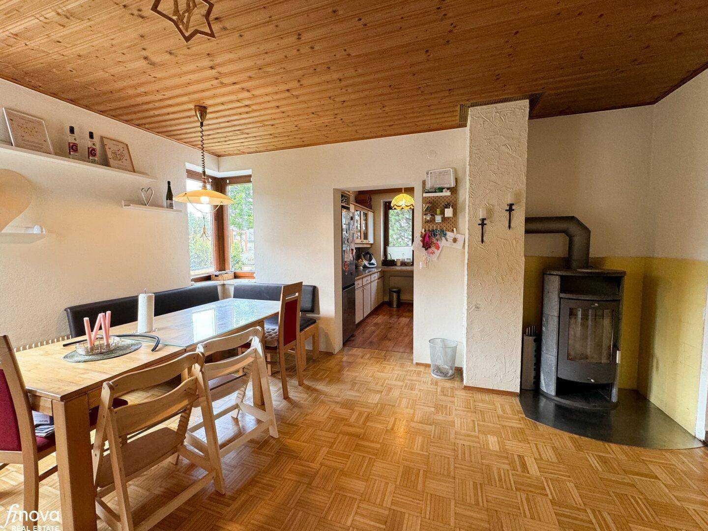 Gemütlicher Essbereich mit Holztisch, Sitzbank und Kaminofen, ideal für gesellige Abende.