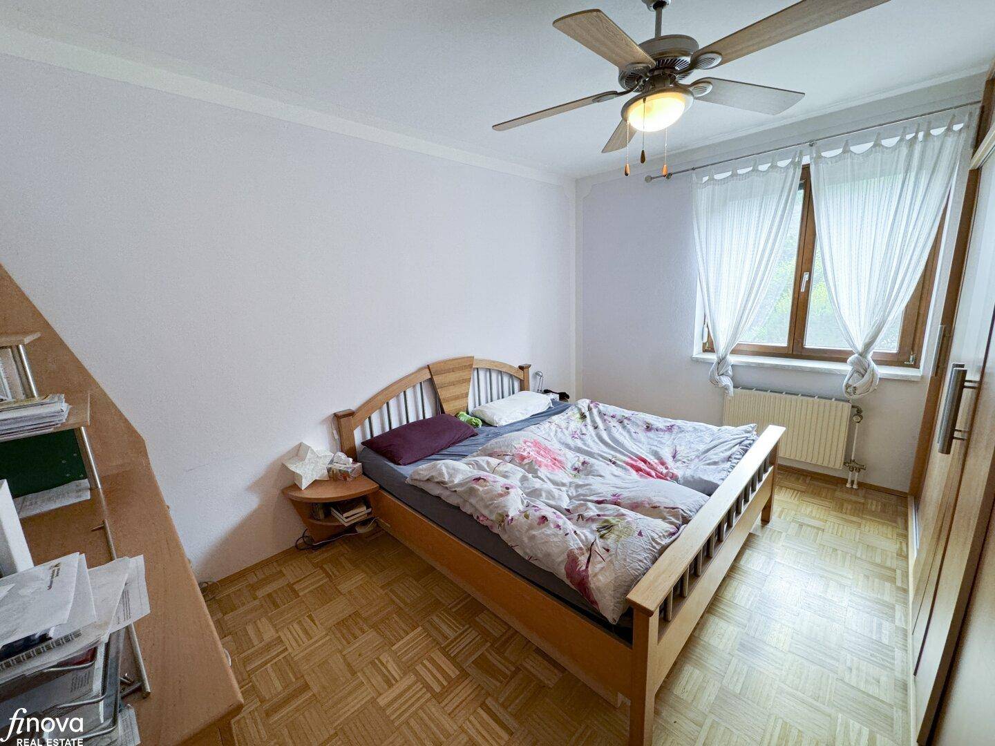 Schlafzimmer mit Doppelbett, Parkettboden und Deckenventilator, sorgt für angenehme Nächte.