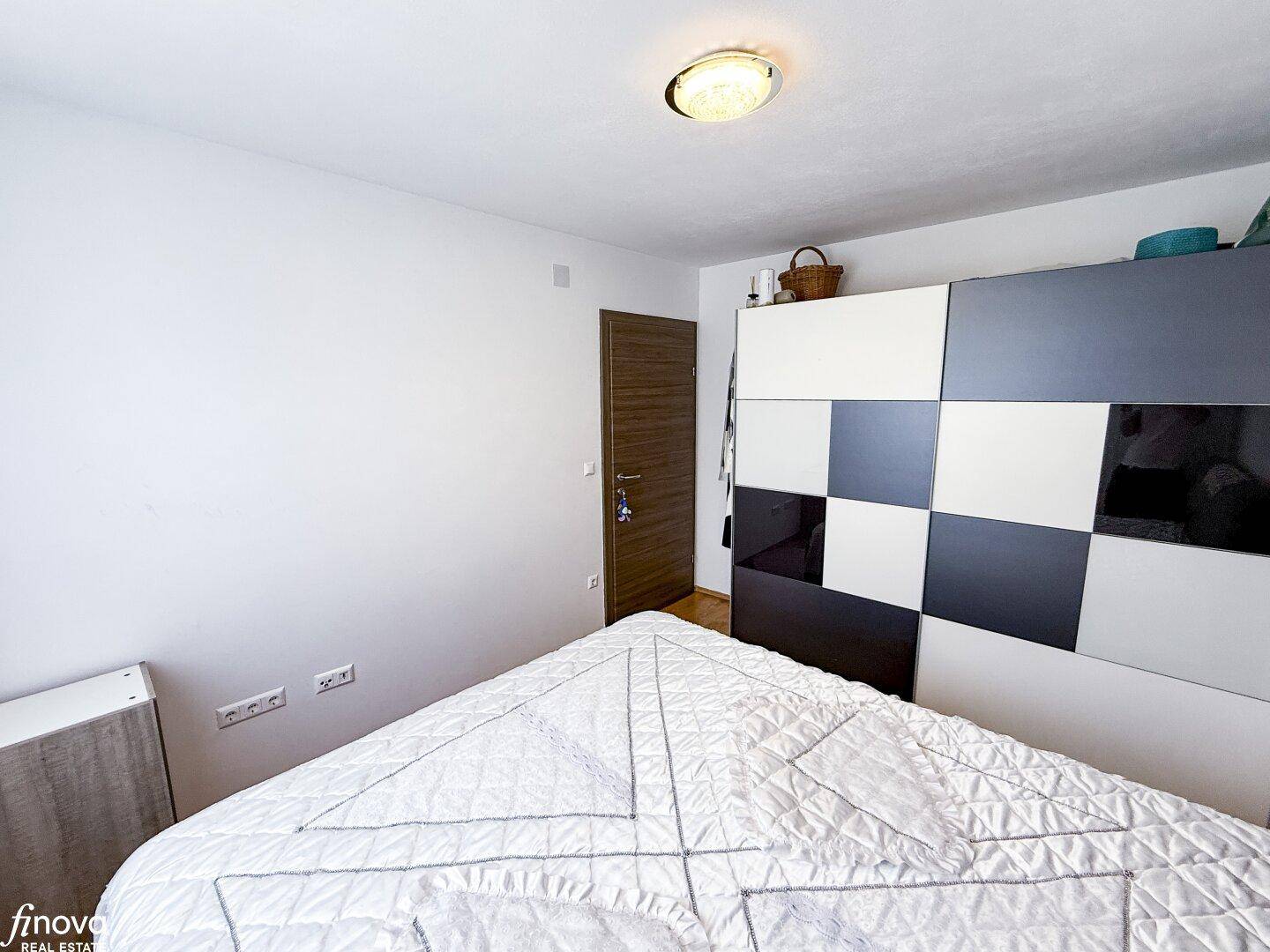 Schlafzimmer mit modernem Kleiderschrank und Holzboden, hell und funktional.