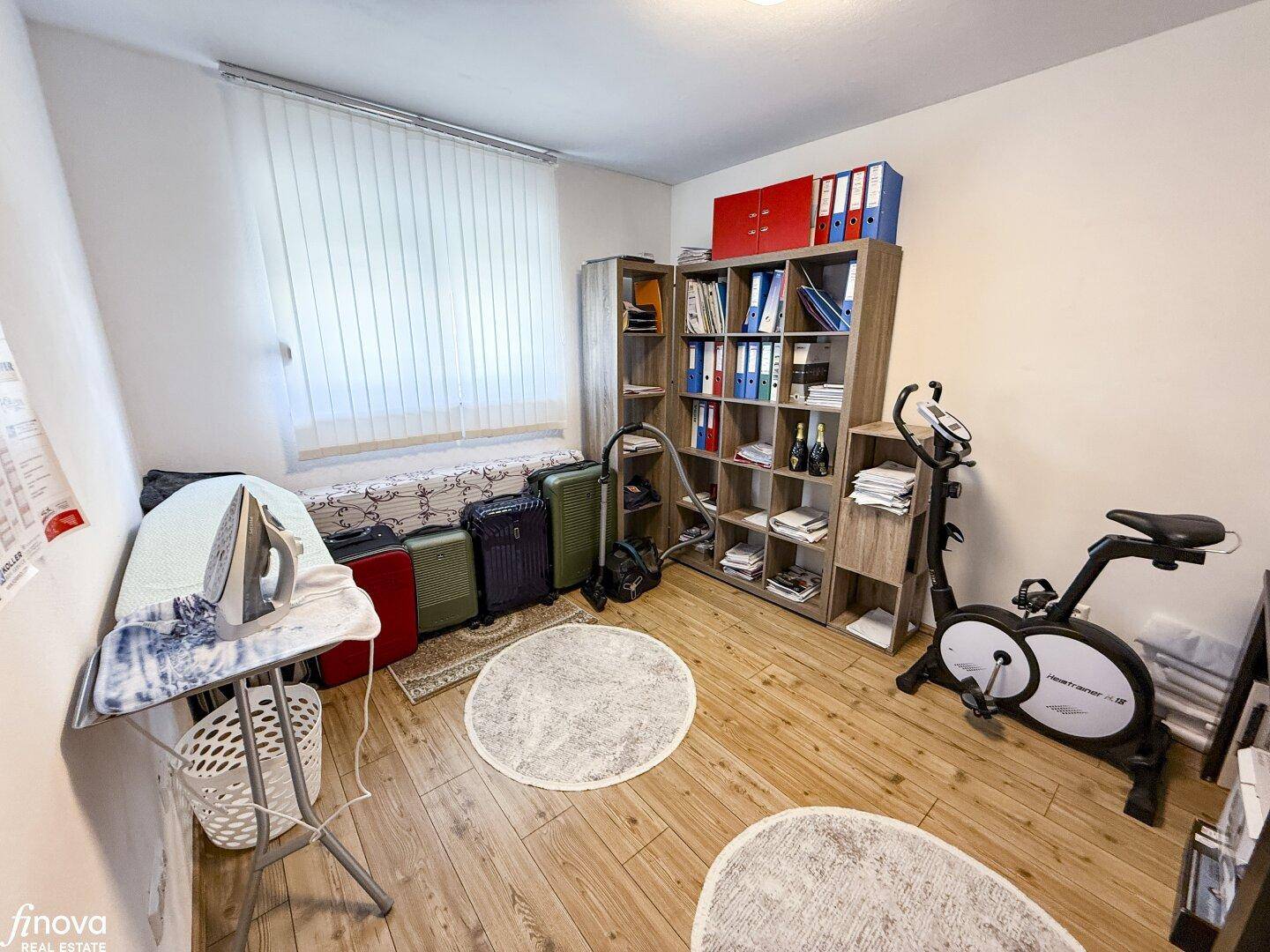 Mehrzweckraum mit Büchern, Sportgerät und Stauraum für Haushaltsgegenstände.
