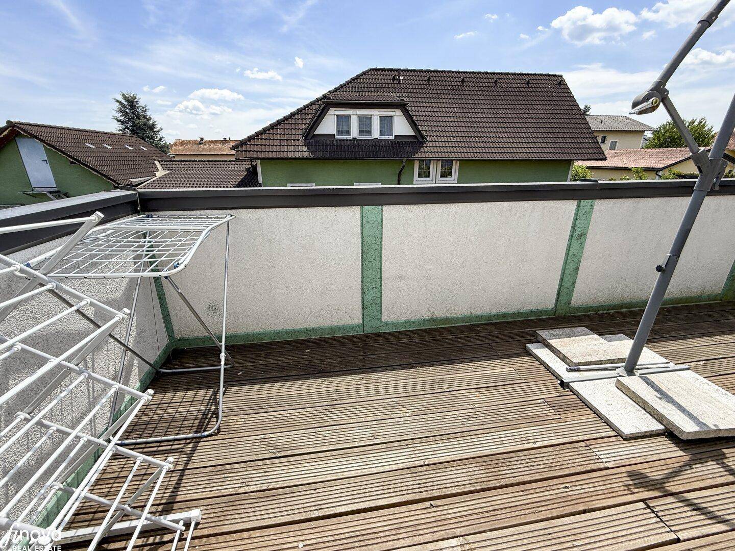 Balkon mit Holzbelag und Wäscheständer, bietet praktischen Außenbereich.
