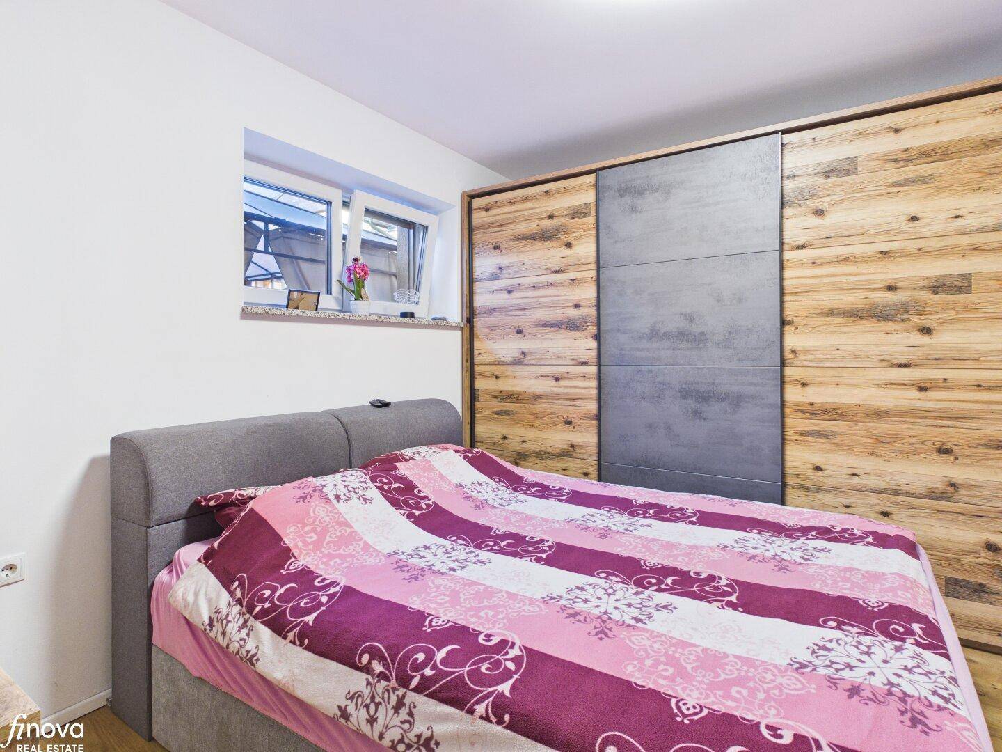 Gemütliches Schlafzimmer mit Holzboden und großem Einbauschrank.