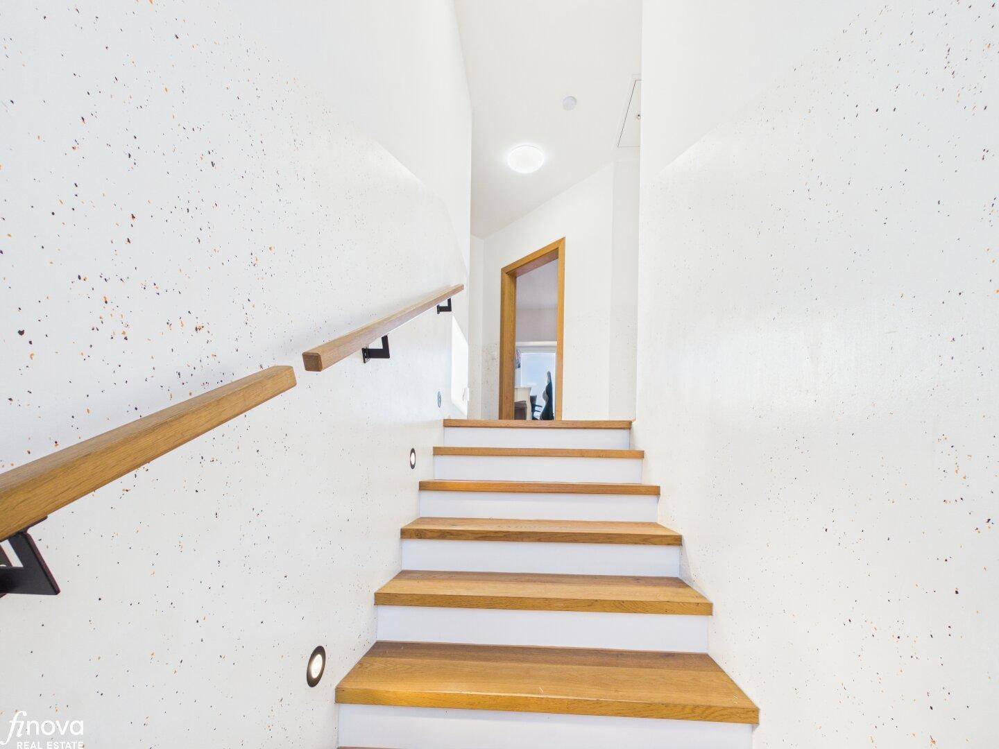 Heller Treppenaufgang mit Holzstufen und minimalistischem Design.