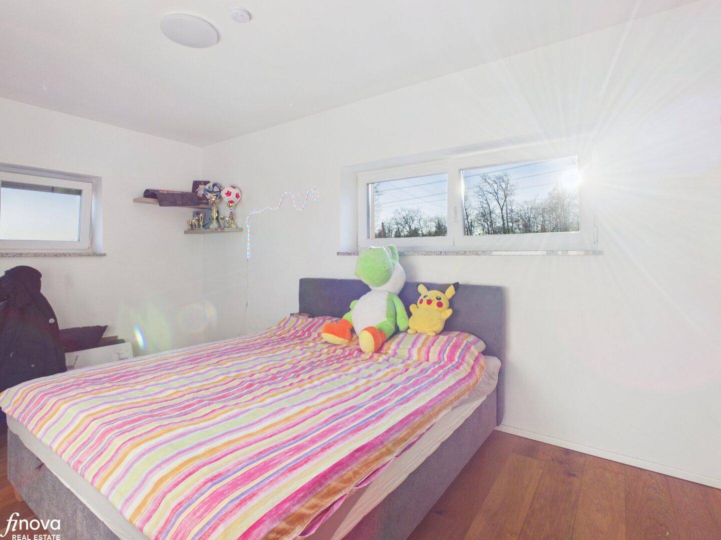 Kinderzimmer mit Holzboden und großen Fenstern für viel Tageslicht.