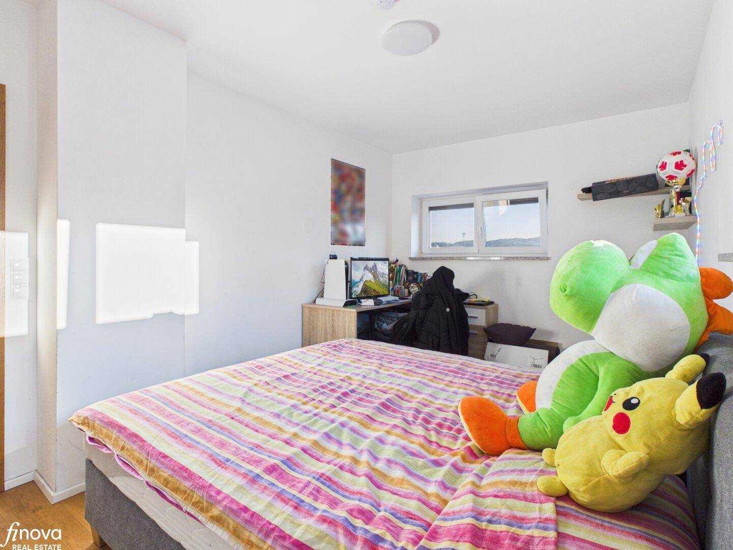Helles Kinderzimmer mit Holzboden und Schreibtischbereich.